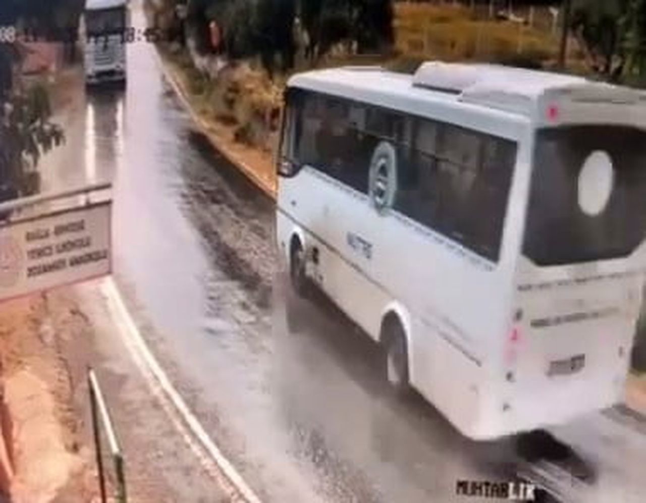 GÜVENLİK KAMERASI GÖRÜNTÜLERİNDE, YAĞIŞ NEDENİYLE KAYGANLAŞAN YOLDA KONTROLDEN ÇIKAN OTOBÜSÜN...