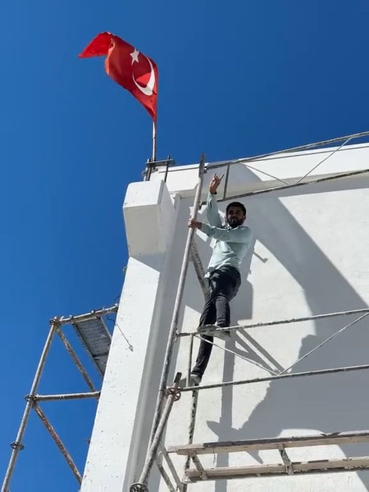 RÜZGÂR NEDENİYLE TERS DÖNEN TÜRK BAYRAĞINI DÜZELTMEK İÇİN YAKLAŞIK 10 METRE YÜKSEKLİĞİNDEKİ İNŞAAT...