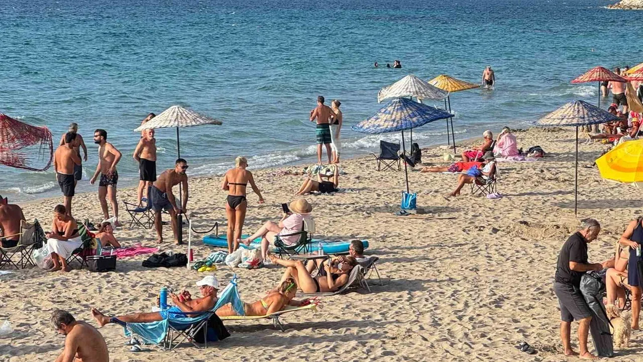 YAZ MEVSİMİNİ ARATMAYAN HAVANIN ETKİLİ OLDUĞU AYDIN'IN KUŞADASI İLÇESİNDE VATANDAŞLAR DENİZE...