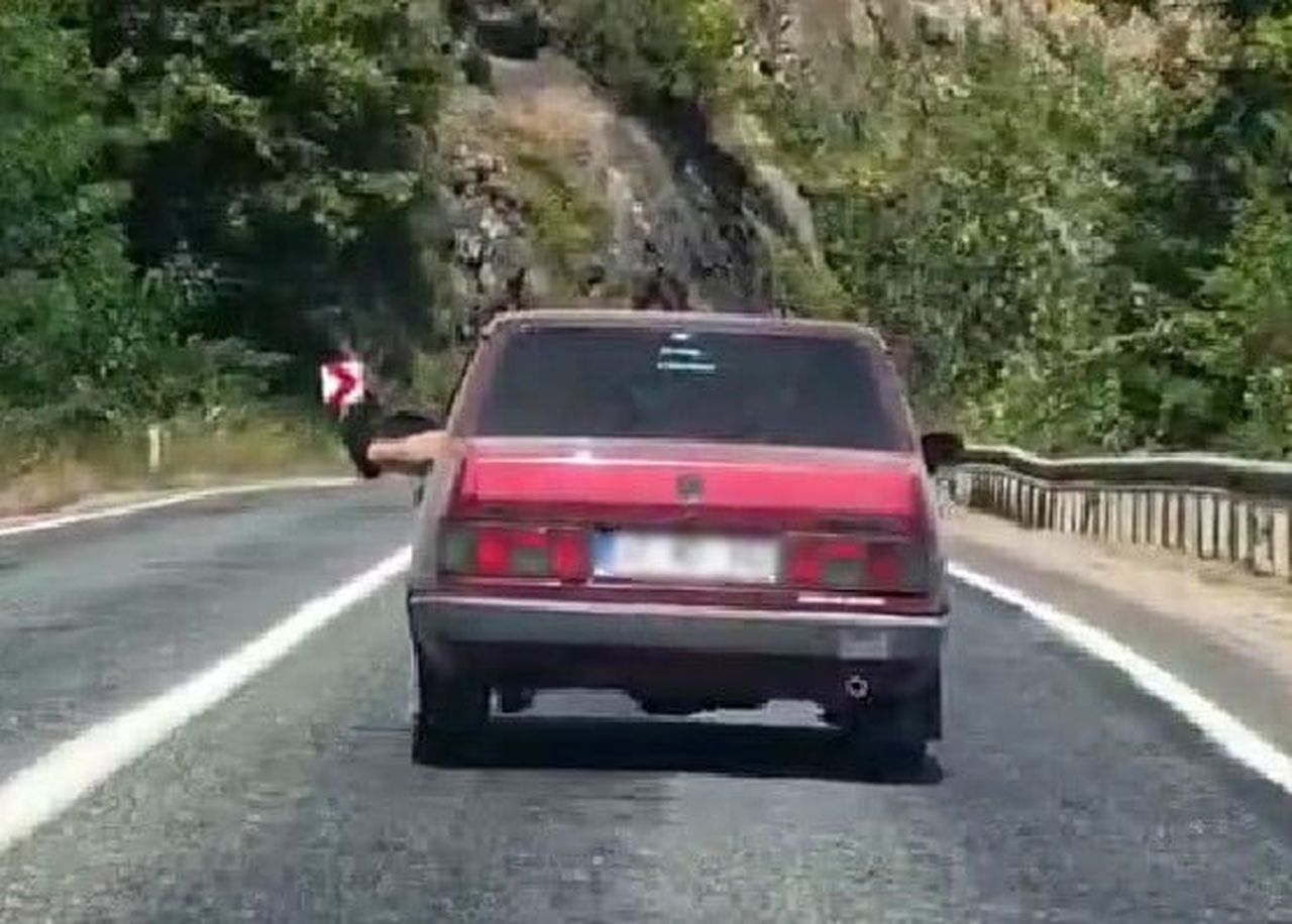 KARABÜK'TE BİR SÜRÜCÜ OTOMOBİLİN CAMINDAN AYAKLARINI DIŞARIYA ÇIKARARAK SEYAHAT EDEREK, TRAFİĞİ...