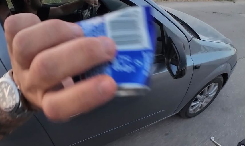 Yoldaki çöpü alıp aracın içine geri atan sürücünün anları kaskta yansıdı