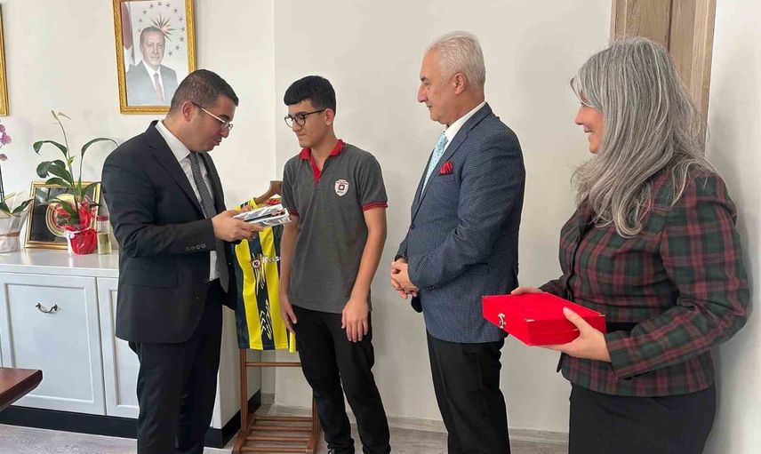 Bayrağı yerde öpüp başına koyan liseli kaymakamlıkta tebrik edildi