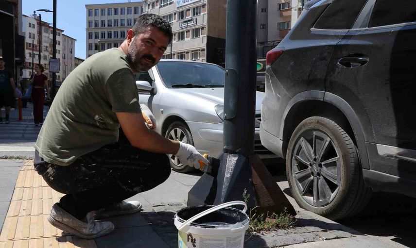 Sivas'ta paslanan aydınlatma direklerini gönüllü boyayan kantinci