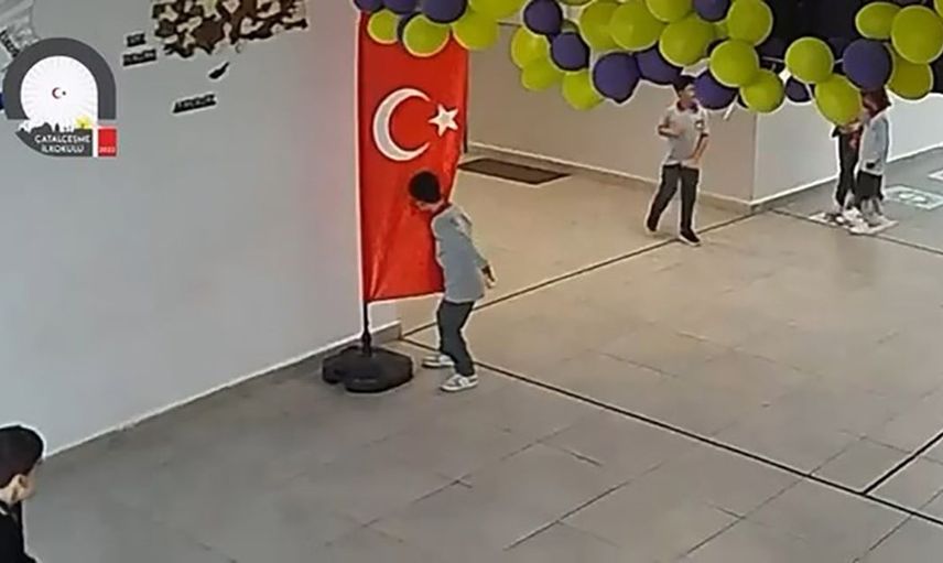Koridorda oyununu kesen çocuk Türk bayrağını öpüp alnına koydu