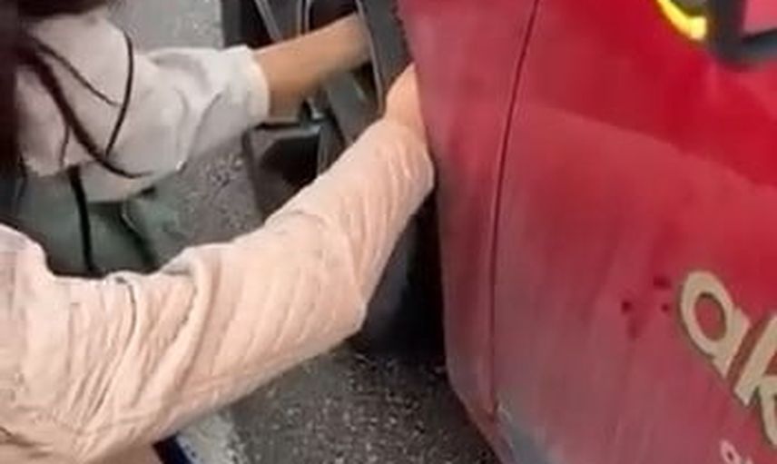 Ana yolda korkuyla aracın tekerine sığınan kedinin kurtarılışı