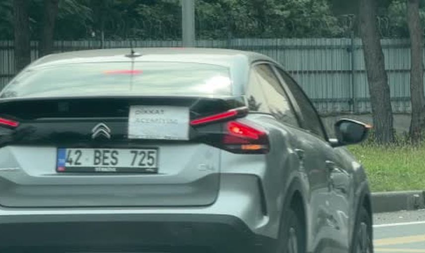 Aracının arka camına 'dikkat acemiyim' yazısı yapıştırdı