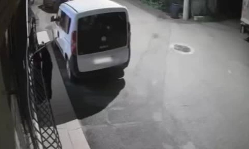 Pencerede kurutulan kıyafetleri pazardan seçer gibi alan kadın kamerada
