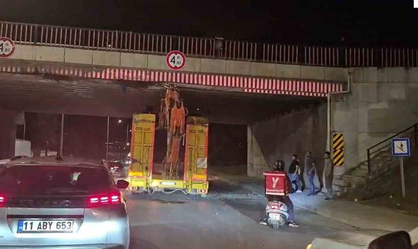 İş makinesi yüklü tırın üst geçide takılması trafik akışını yavaşlattı