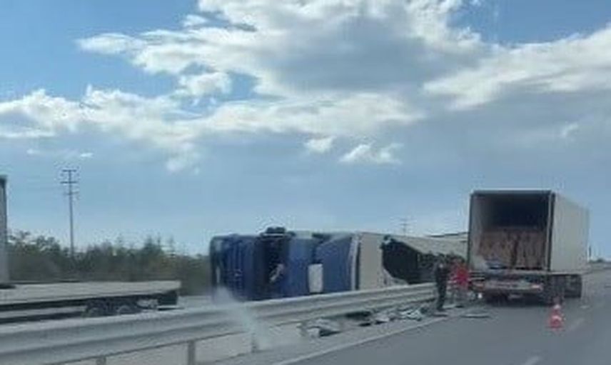 Refüjde devrilen tır yola saçılan yükle trafiği aksattı