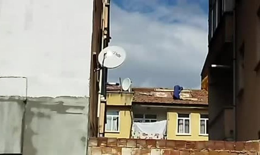 Çatıya çıkarak halı serdi, çevredekileri endişelendirdi