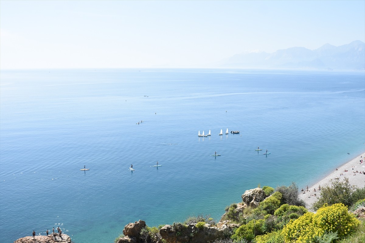 Antalya'da güneşli havayı değerlendirmek isteyen kent sakinleri ve turistler, sahillerde...