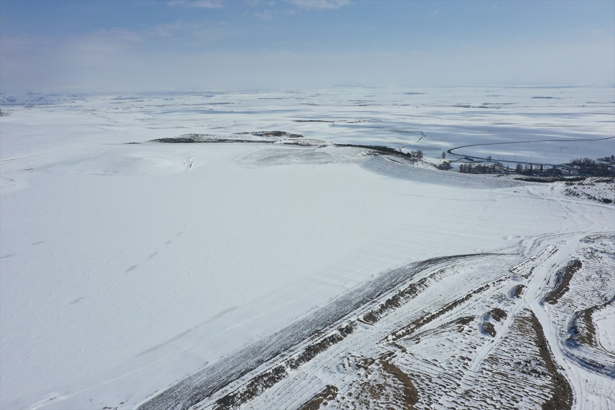 Kars'ta soğuk havanın etkisiyle yüzeyi donan Bayburt Barajı, kar yağışıyla yeniden beyaza...