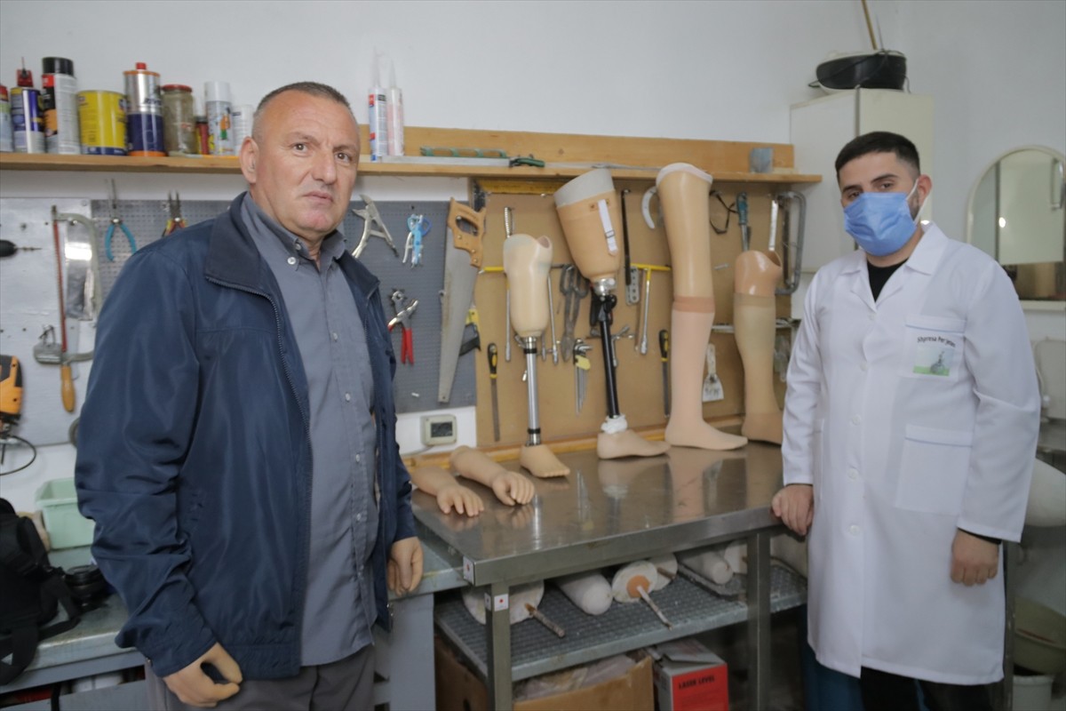 Arnavutluk'un başkenti Tiran'da, protez kol ve bacaklar kullanan İzet Onuzi (solda), atölyesinde...