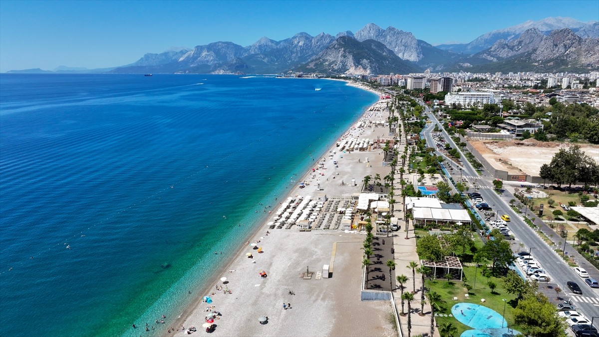 Antalya'da sıcak hava ve nemden bunalan yerli ve yabancı turistler, sahillerde ve gölgelik...