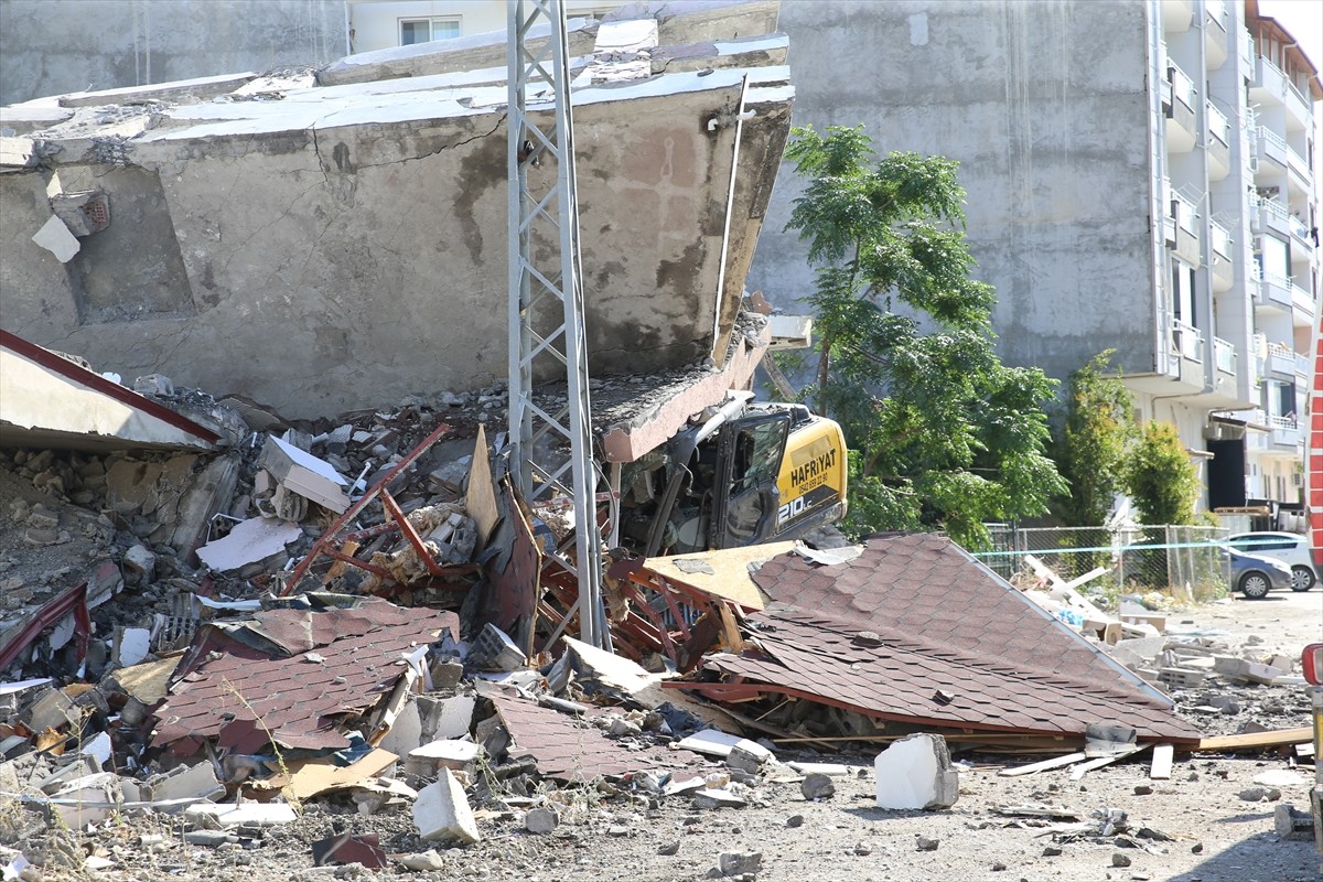 Hatay'ın Arsuz ilçesinde, ağır hasarlı bir binanın yıkımı sırasında iş makinesinin üzerine çökmesi...