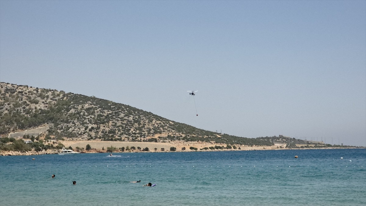 Mersin'in Silifke ilçesinde ağaçlık alanda çıkan yangın, ekiplerin havadan ve karadan...
