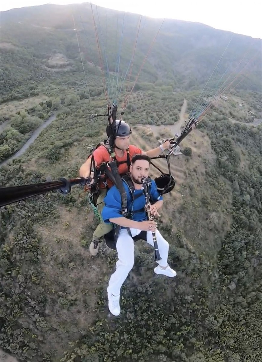 Tekirdağ'ın Şarköy ilçesine gezmeye gelen Yaşar Gümüş, yamaç paraşütüyle uçarken klarnet...