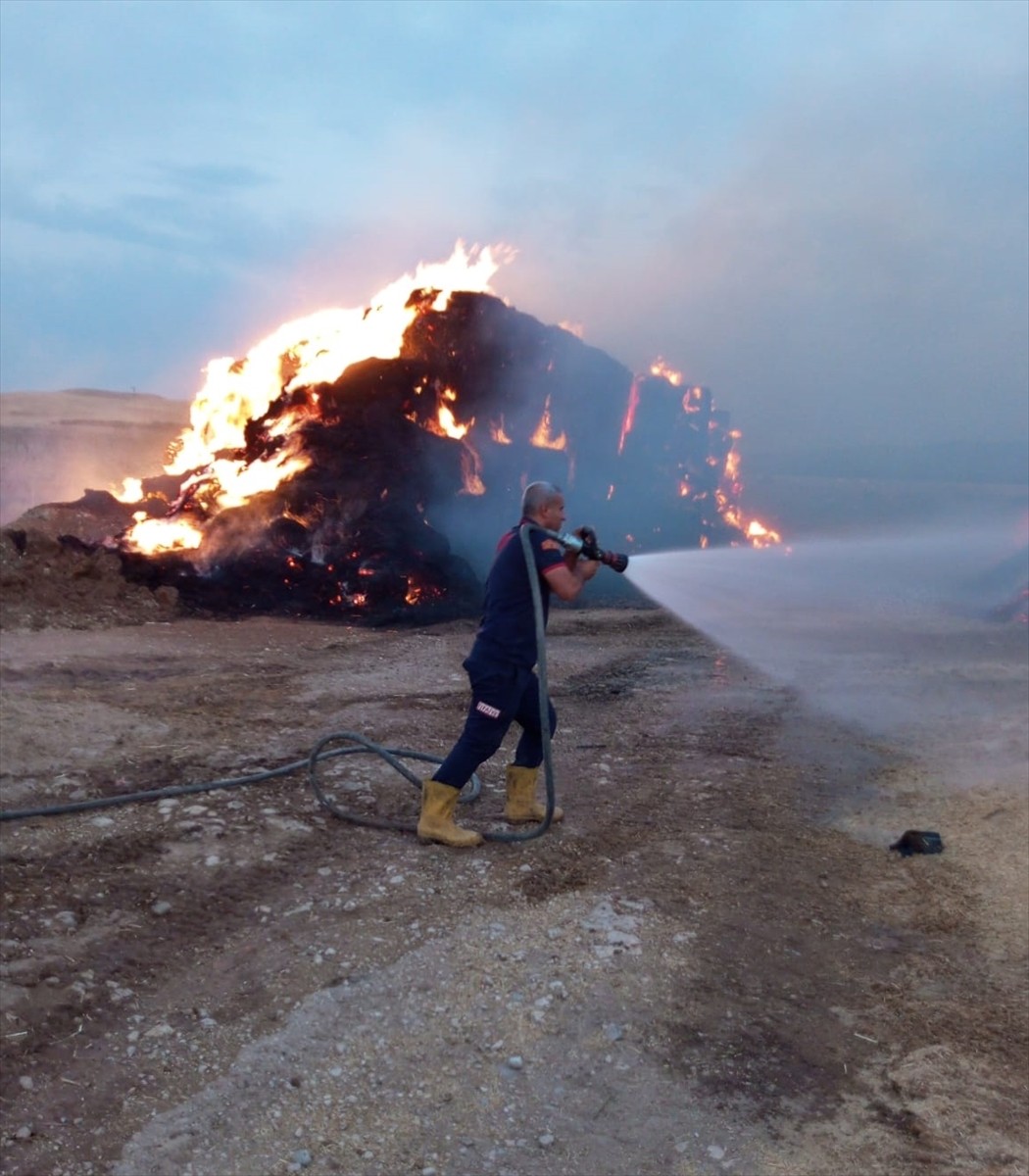  Siirt'in Kurtalan ilçesinde açık alanda istiflenen saman balyalarında çıkan yangın ekiplerin...