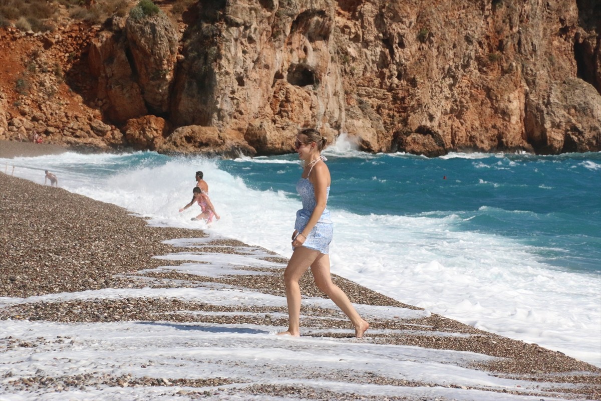 Antalya'da havanın bulutlu ve suyun dalgalı olmasına rağmen bazı yabancı turistler denizde...