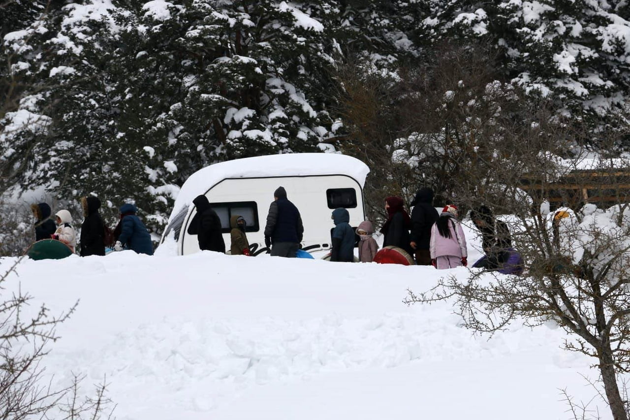 ABANT GÖLÜ MİLLİ PARKI'NDA KÖYLÜLERİN OLUŞTURDUĞU DOĞAL PİSTTE ÇOCUKLAR ŞAMBRELLERLE KAYARAK KARIN...