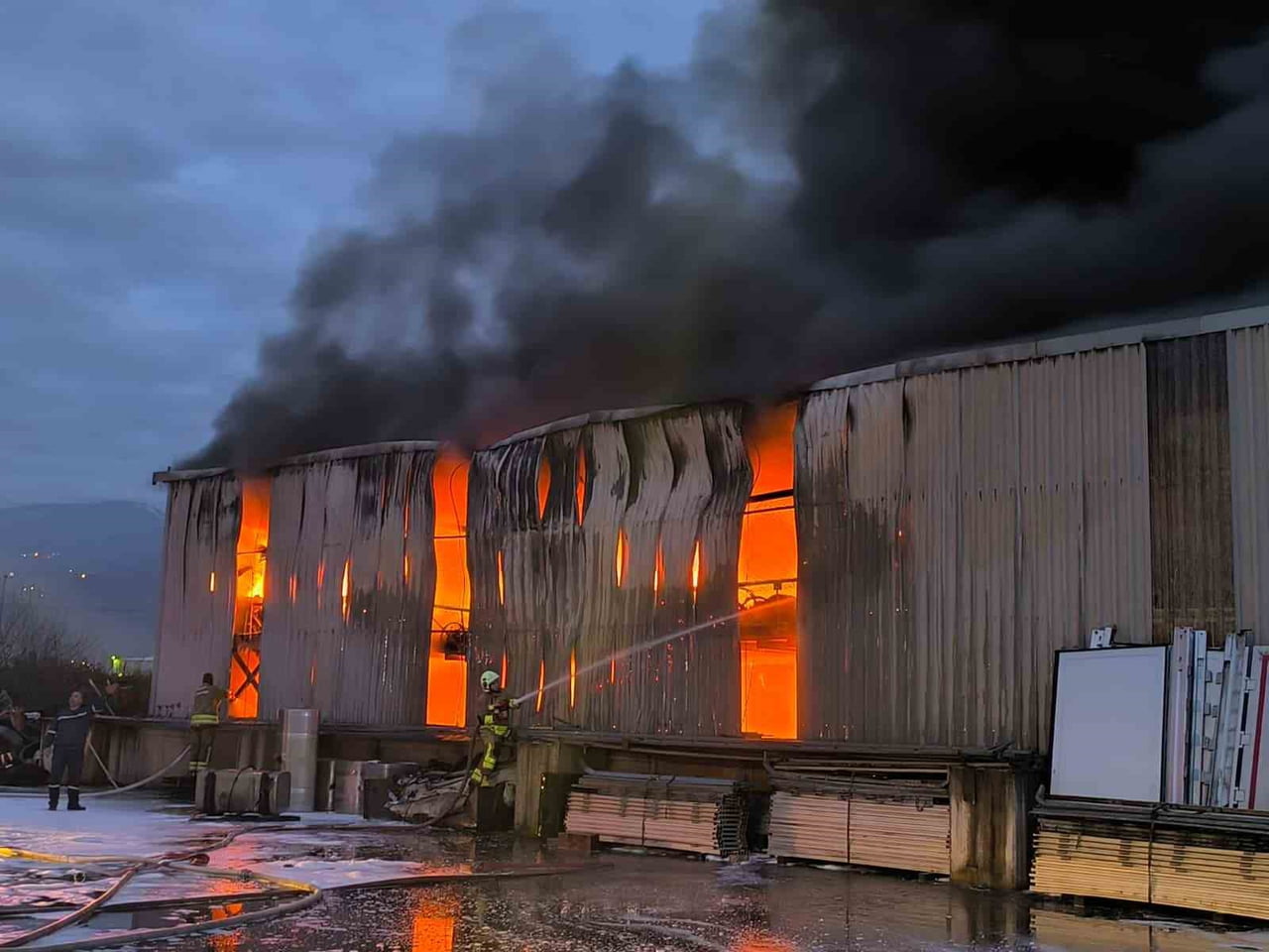 HATAY’DA ALEVLERE TESLİM OLAN ULTRANS LOJİSTİĞE AİT LASTİK DEPOSUNDAKİ YANGINA İTFAİYE EKİPLERİNİN...