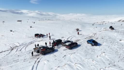 Karla kaplı dağdan donmuş gölete botla kaydılar