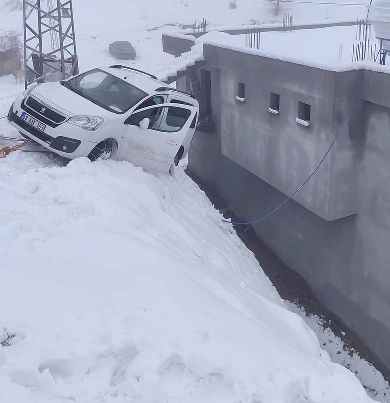 SİİRT’İN BAYKAN İLÇESİNDE BUZLU YOLDA KAYAN HAFİF TİCARİ ARAÇ BİR EVİN DUVARINDA ASILI...