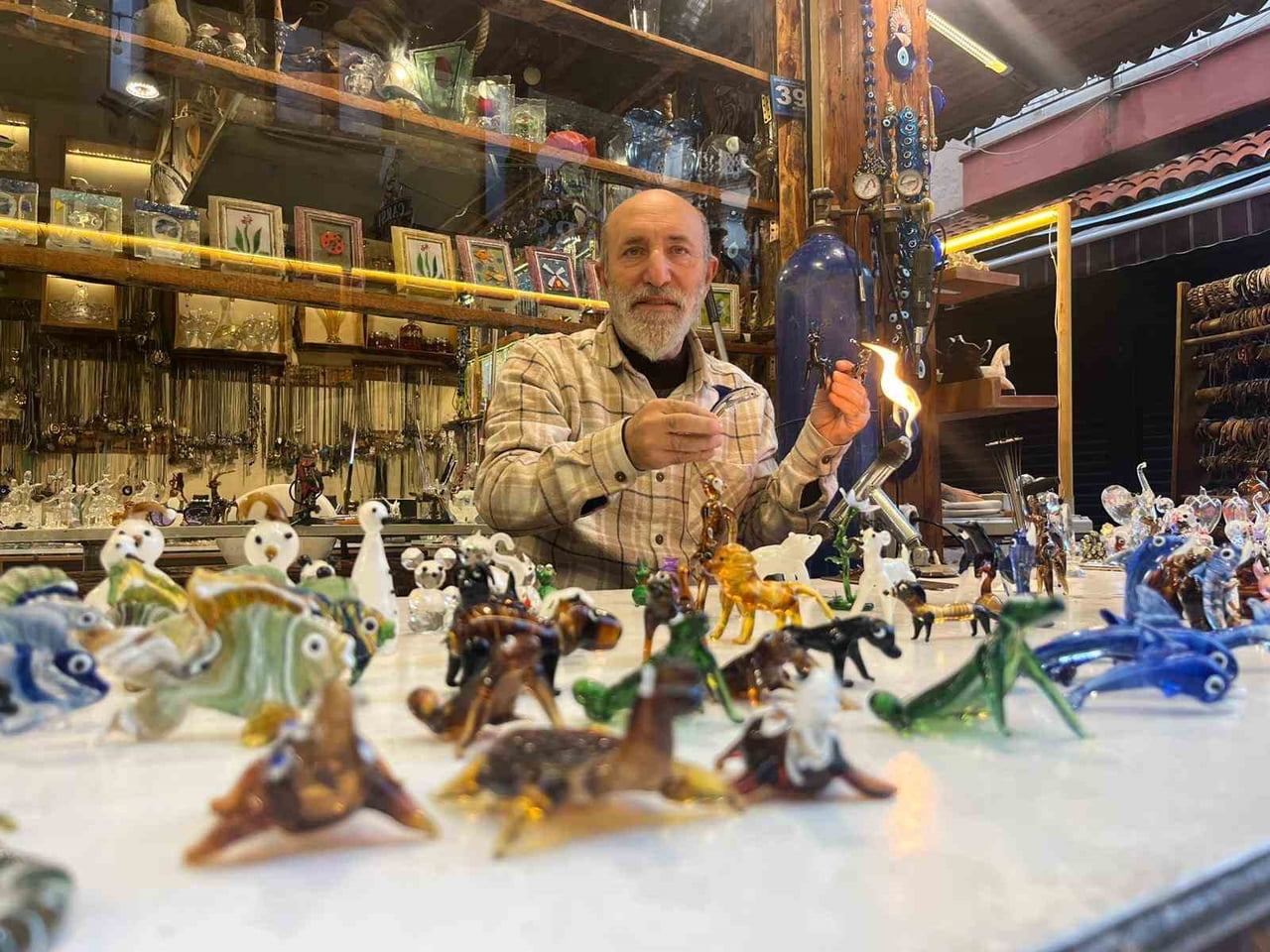 ANTALYA’NIN ALANYA İLÇESİNDE YAŞAYAN 62 YAŞINDAKİ CAM ÜFLEME USTASI HAMİT PAŞAOĞLU, ATEŞLE...