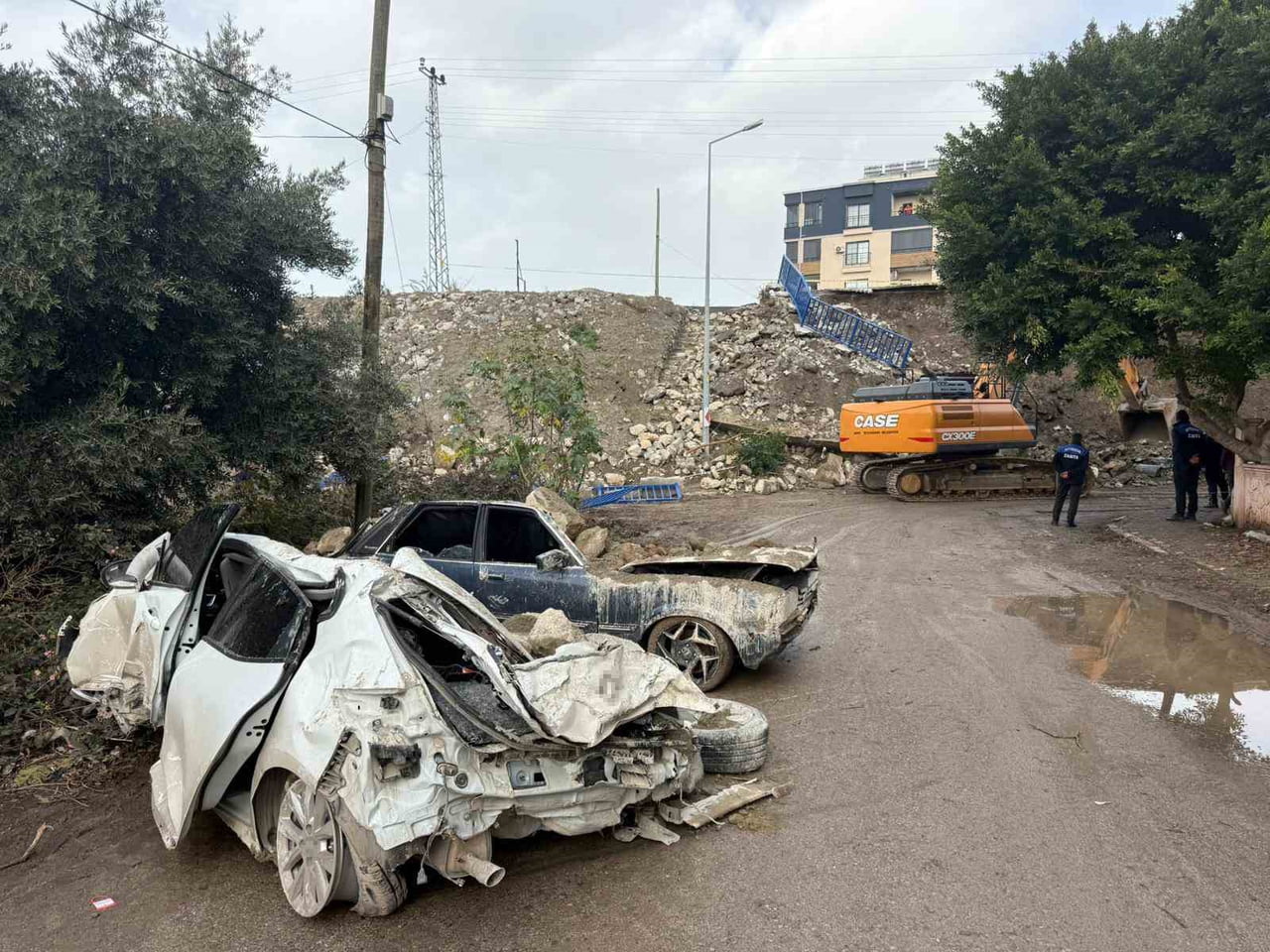 HATAY’DA ÇÖKEN İSTİNAT DUVARININ ALTINDA KALARAK HURDAYA DÖNEN ARAÇLAR EKİPLERİN ÇALIŞMALARIYLA...